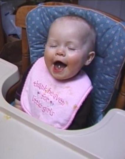 Sabrina laughing in her high chair