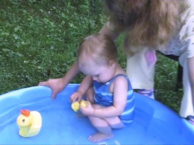 Sabrina playing with rubber duckies in her wading pool